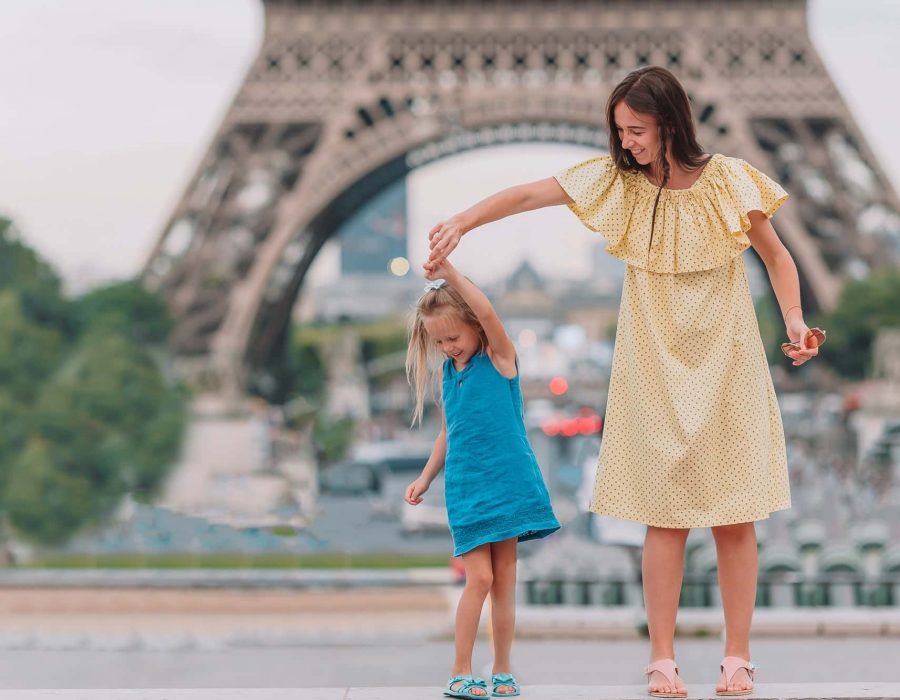 Little adorable girl and her young mom in Paris near Eiffel Tower during summer vacation